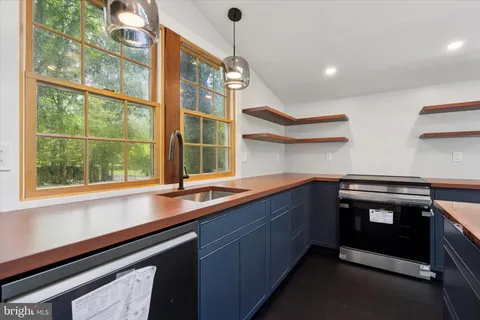 a kitchen with stainless steel appliances granite countertop a sink and a window