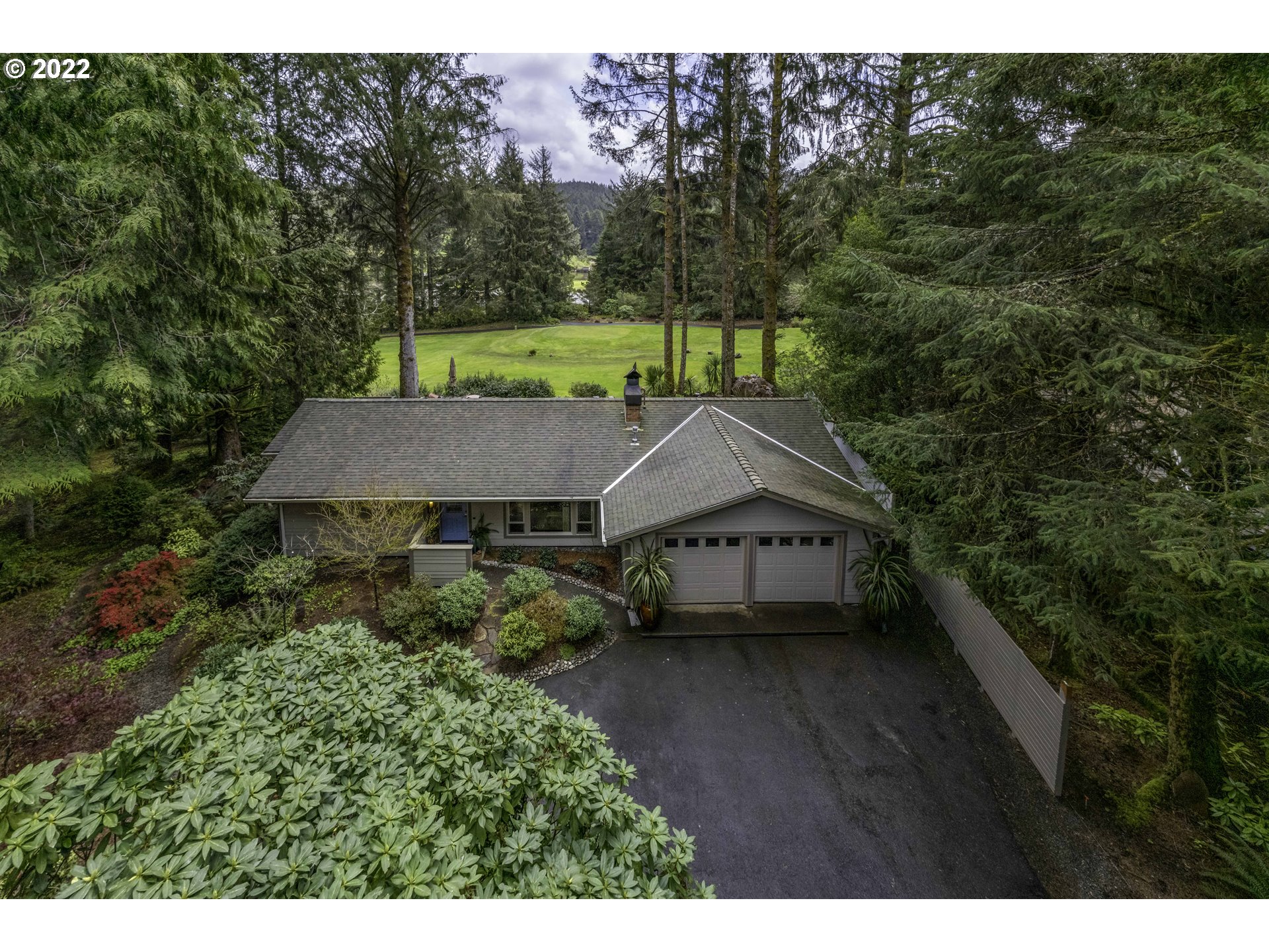104 East Bay Point Road Gleneden Beach, OR 97388 - Photo 1 of 31 a view of a house with a yard plants and large tree