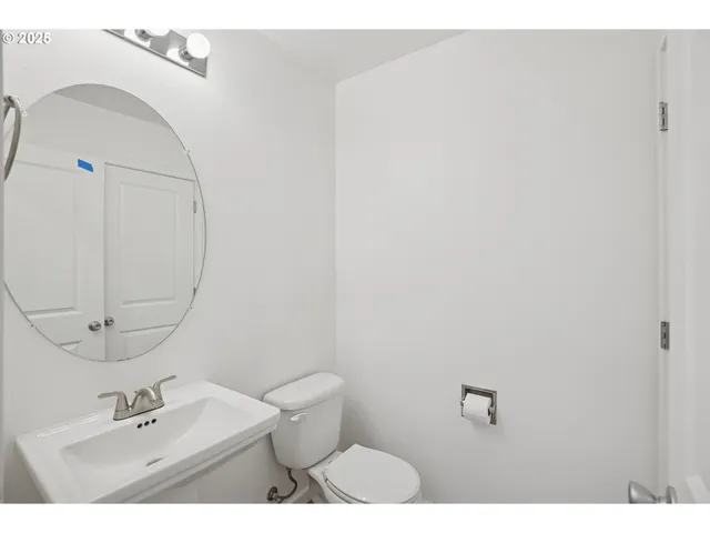 a bathroom with a sink mirror and toilet