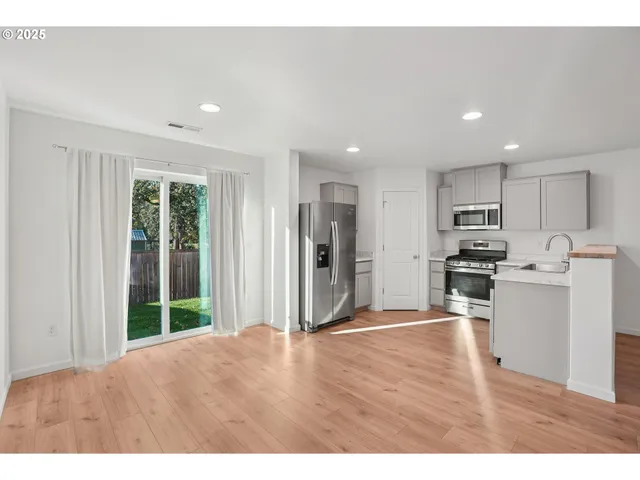 a kitchen with stainless steel appliances granite countertop a refrigerator and a stove top oven