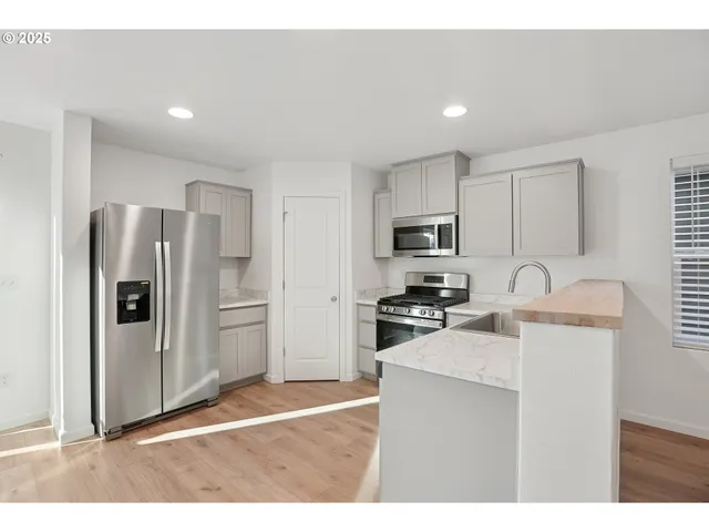 a kitchen with stainless steel appliances granite countertop a refrigerator sink and stove