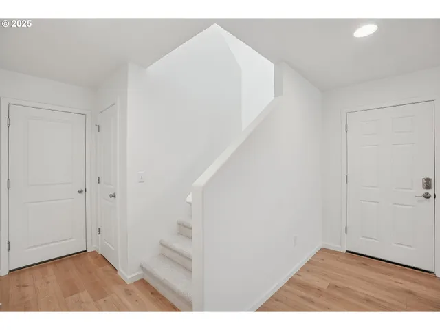 a view of an empty room with stairs and a hallway