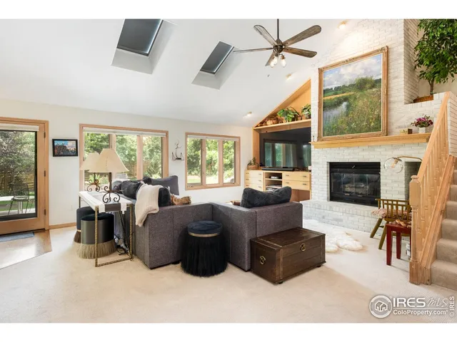 a living room with furniture a large window and a fireplace