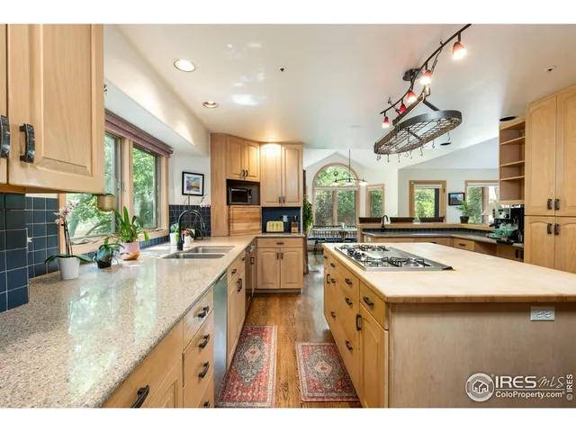 a kitchen with kitchen island a sink appliances and a counter top