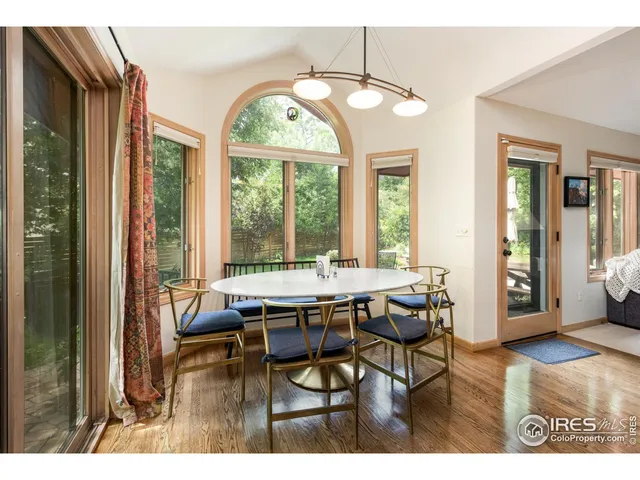 a dining room with furniture a chandelier and wooden floor