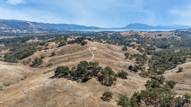 a view of a dry yard with mountain and lake view