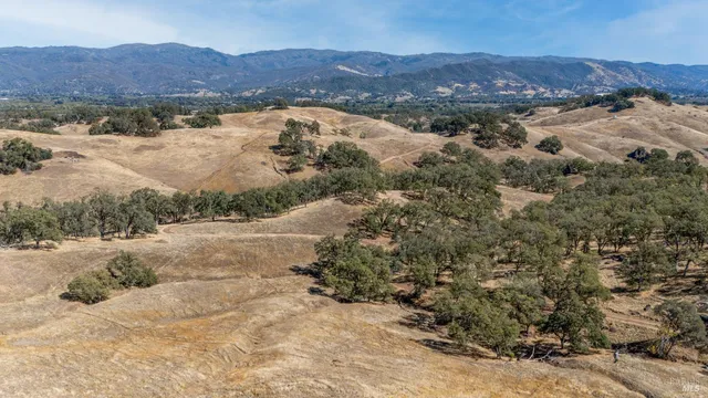 a view of a large building with mountains in the background