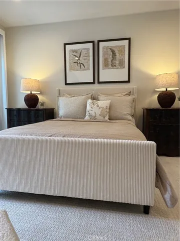 a bedroom with a bed and painting on the wall