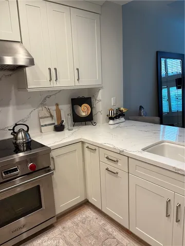 a kitchen with white cabinets and appliances