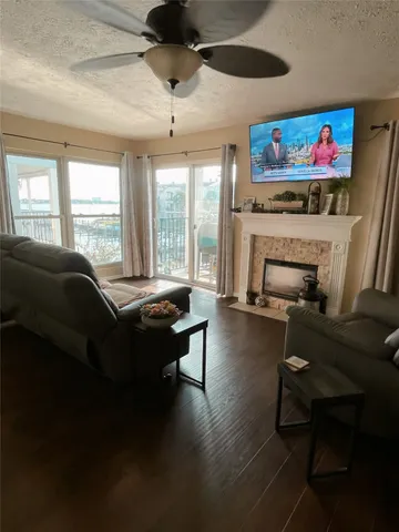 a living room with furniture a flat screen tv and a floor to ceiling window