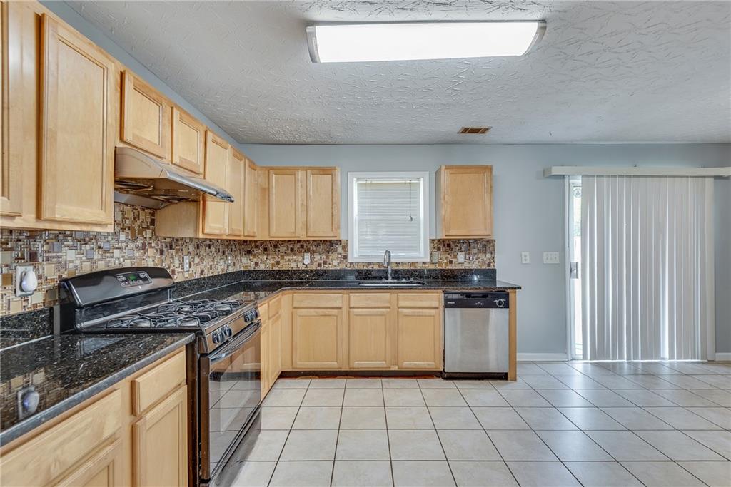 3337 Baymount Way Lawrenceville, GA 30043 - Photo 14 of 47 a kitchen with stainless steel appliances granite countertop a stove a sink and a microwave