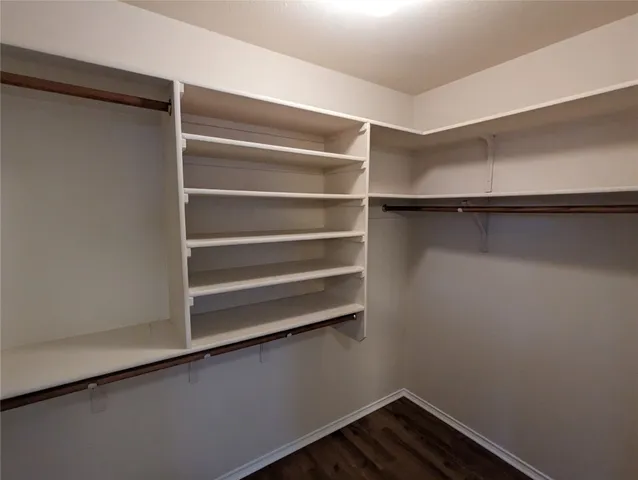 a view of walk in closet with empty racks