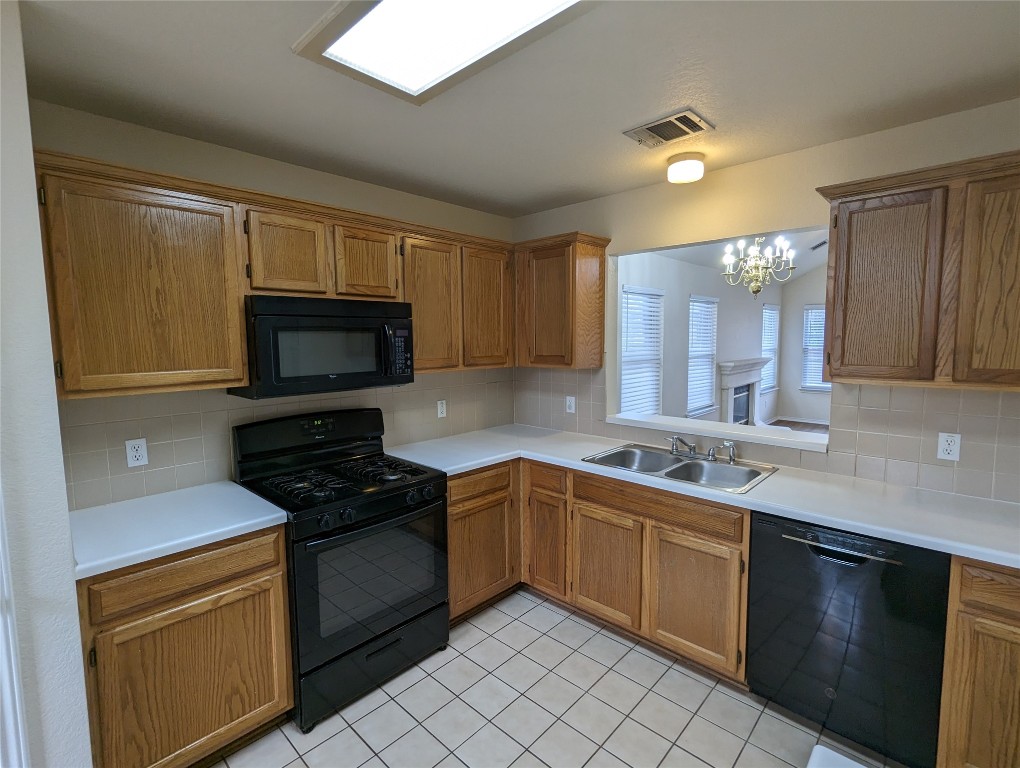 13512 Albania Way Austin, TX 78729 - Photo 7 of 24 a kitchen with a sink stove and microwave