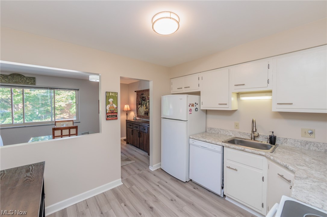 1750 Wagar Road, Unit 206 Rocky River, OH 44116 - Photo 17 of 33 Kitchen featuring plenty of countertops, white cabinets, white appliances, LVP flooring