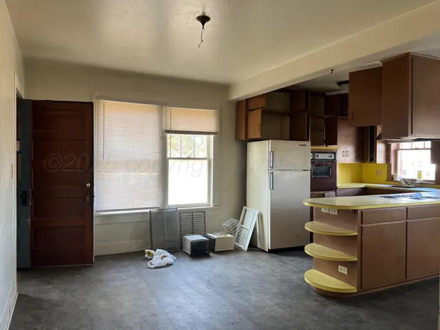 a view of a kitchen with fridge and workspace