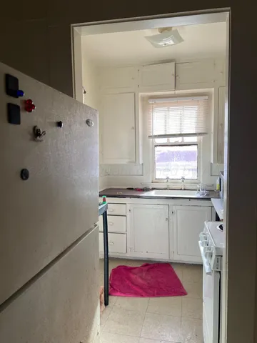 a room with granite countertop a sink and a refrigerator