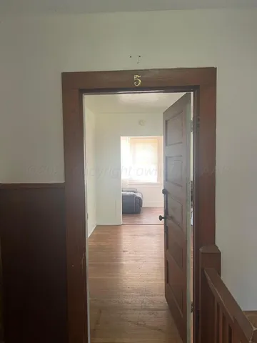 a view of a hallway to a livingroom and a window