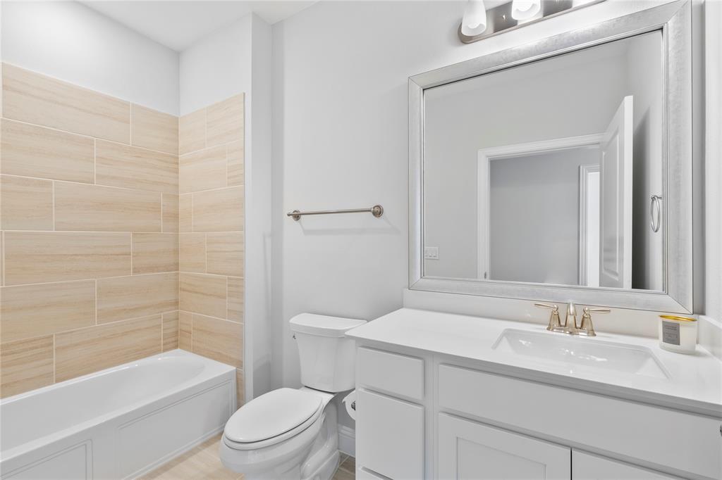 651 Watters Road, Unit 4403 Allen, TX 75013 - Photo 23 of 37 a bathroom with a granite countertop toilet a sink and a bathtub