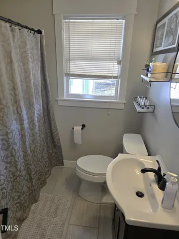 a bathroom with a sink and mirror with toilet