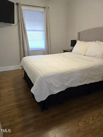 a large bed sitting in a bedroom next to a window