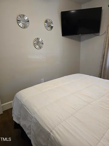 a bedroom with a bed and a flat screen tv