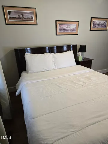 a large bed in a bedroom with a painting on the wall