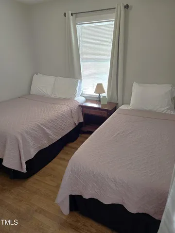 a bedroom with two beds and a window