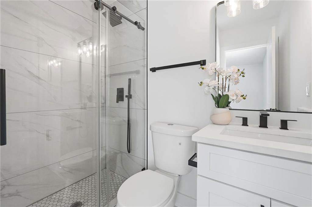 2118 Glendale Drive Decatur, GA 30032 - Photo 20 of 23 a bathroom with a granite countertop sink toilet a mirror and shower