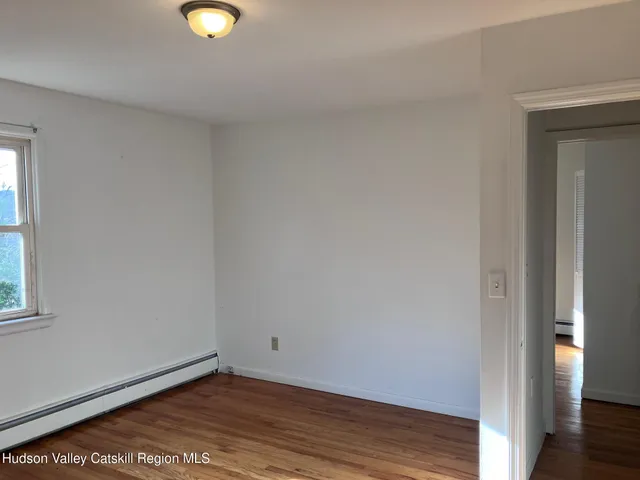 a view of a small space with wooden floor and a window