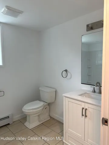 a bathroom with a sink a toilet and a mirror