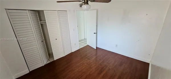 a view of a hallway with wooden floor and stairs
