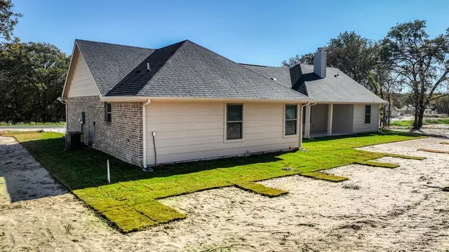 a view of a house with a yard and fence
