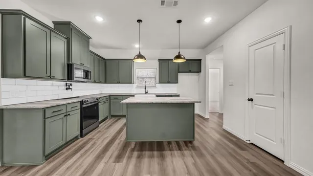 a kitchen with stainless steel appliances granite countertop a sink a stove and a wooden floors