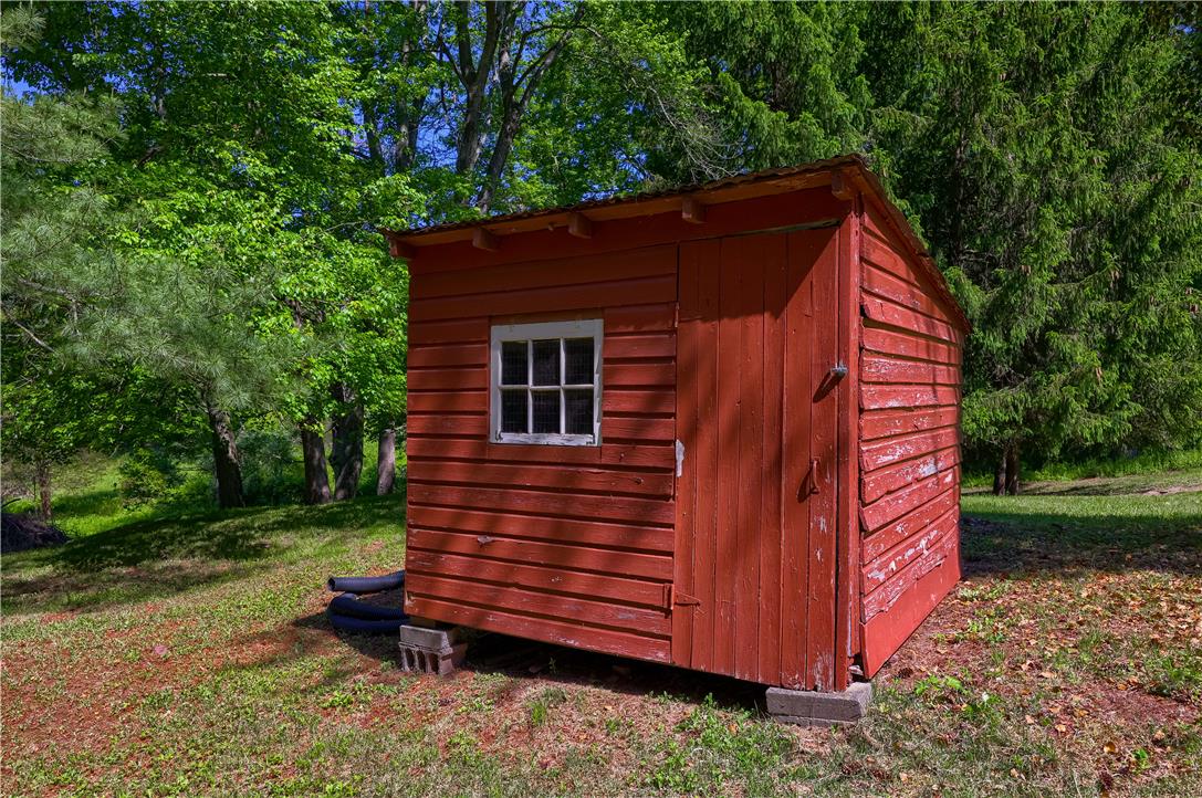 Coldsprings Rd Union Pottstown, PA 19465 - Photo 3 of 71 A quaint red shed stands ready for tools or garden supplies amid verdant trees.