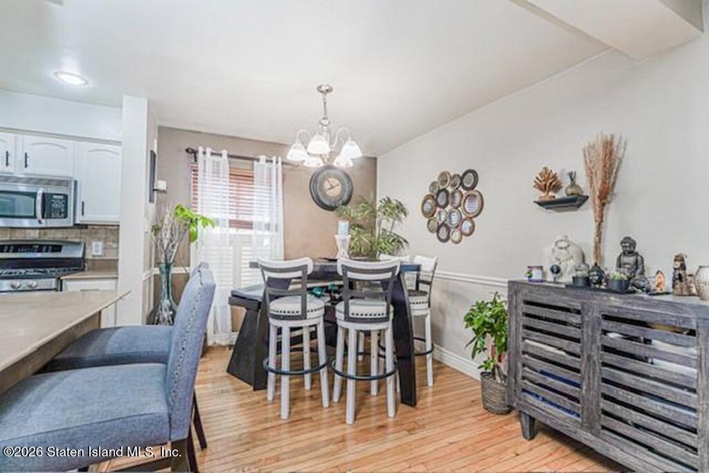 a view of a dining room and livingroom with furniture wooden floor and a clock