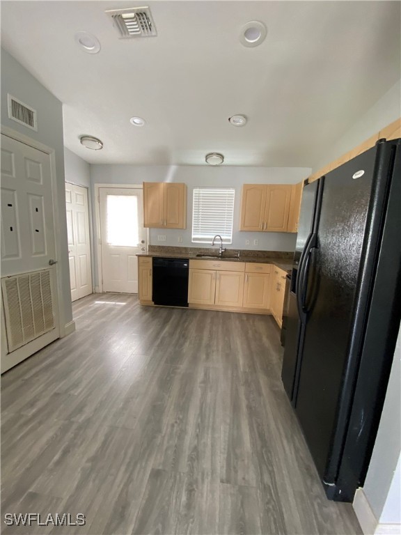 5527 Judith Road, Unit B Bokeelia, FL 33922 - Photo 2 of 8 a kitchen with granite countertop a refrigerator a sink dishwasher a stove and white countertops with wooden floor