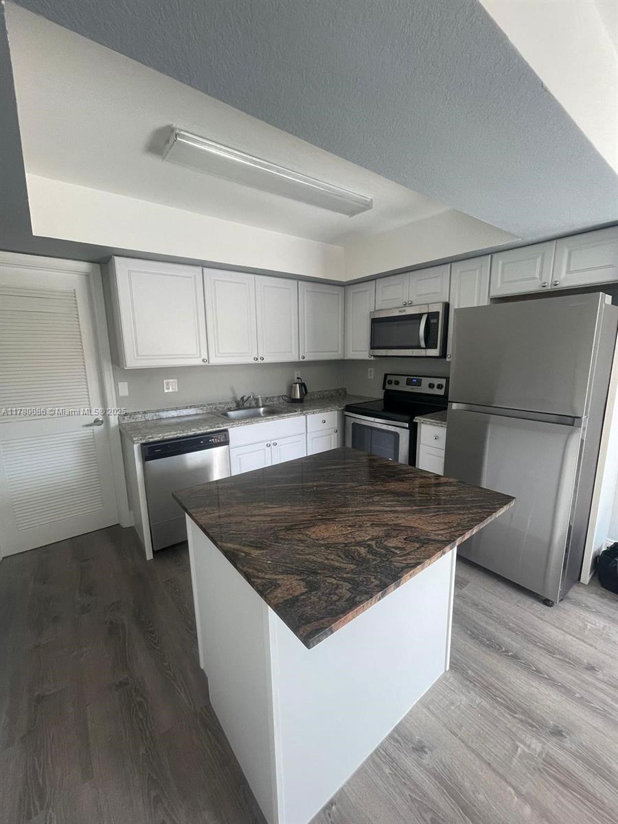Boynton Beach Boynton Beach, FL 33435 - Photo 16 of 22 a kitchen with stainless steel appliances granite countertop a table chairs and a refrigerator