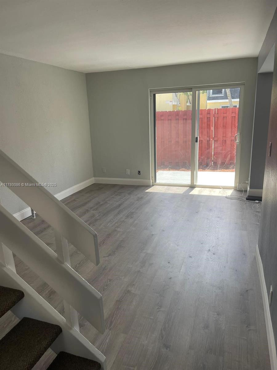 Boynton Beach Boynton Beach, FL 33435 - Photo 19 of 22 an empty room with wooden floor and windows