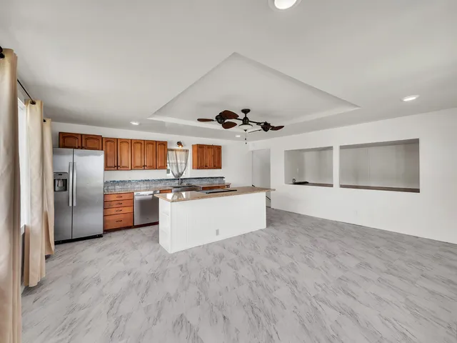 a kitchen with stainless steel appliances granite countertop a stove a sink and a refrigerator