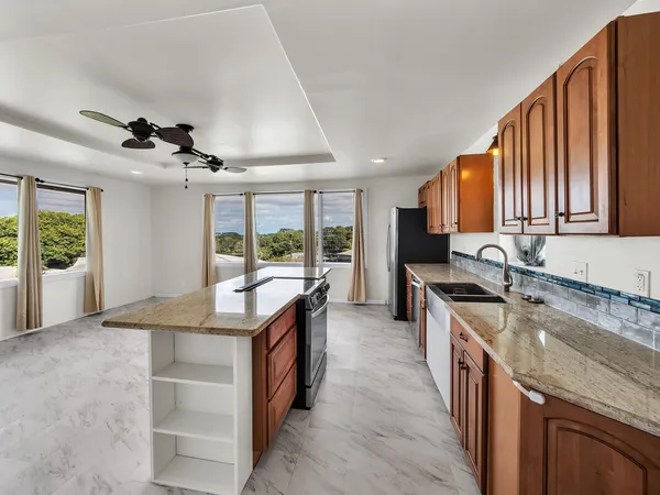 a kitchen with granite countertop a stove and a sink