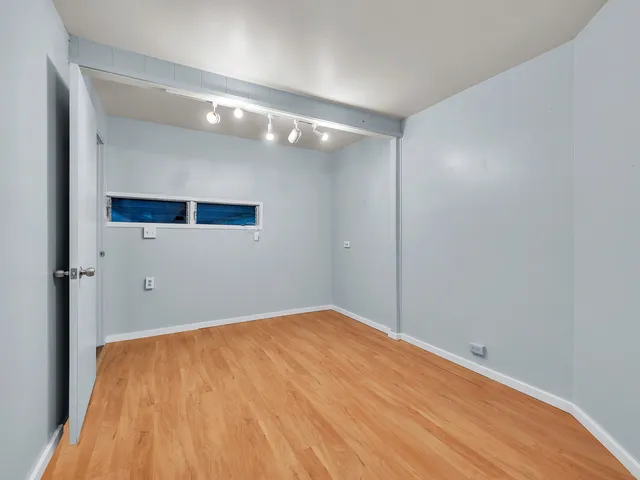 a view of an empty room with wooden floor