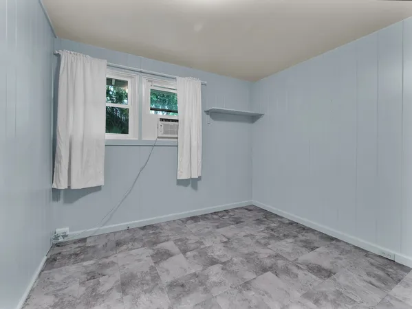 an empty room with wooden floor & windows and bathroom