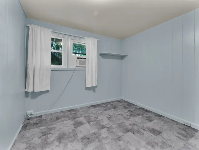 an empty room with wooden floor & windows and bathroom