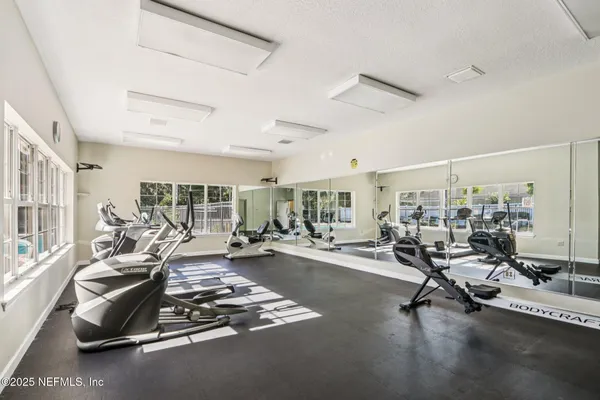 a room with gym equipment and large windows