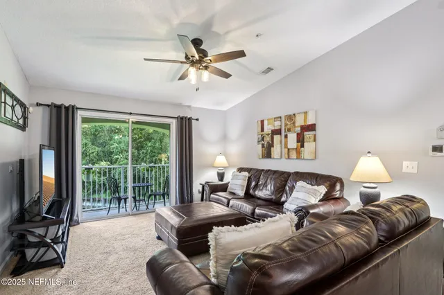 a living room with furniture a large window and a flat screen tv