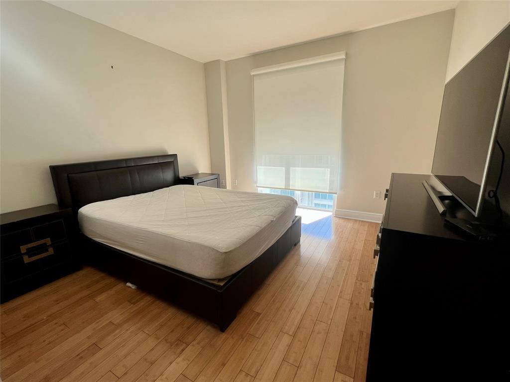 7275 Southwest 89th Street, Unit B520 Miami, FL 33156 - Photo 12 of 26 a bedroom with a bed and a flat tv screen on a dresser