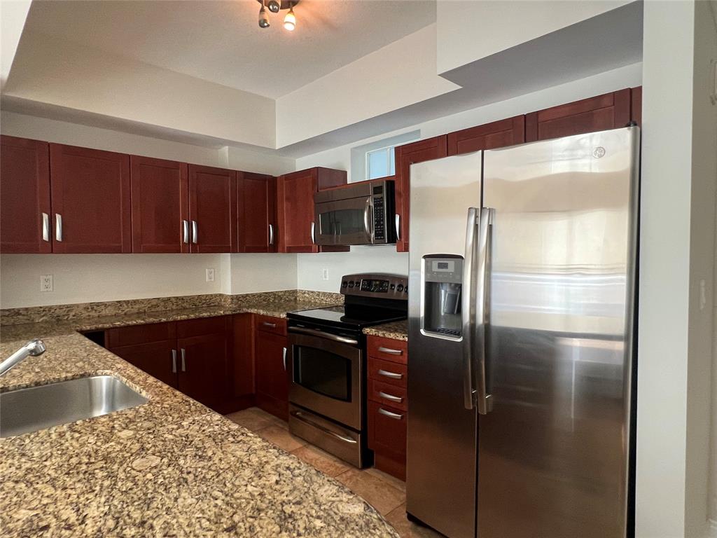 7275 Southwest 89th Street, Unit B520 Miami, FL 33156 - Photo 5 of 26 a kitchen with a refrigerator sink and cabinets