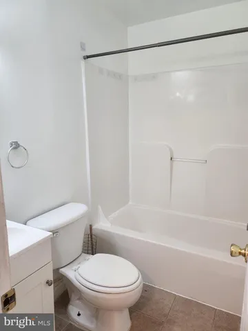 a white toilet sitting next to a bath tub and a shower