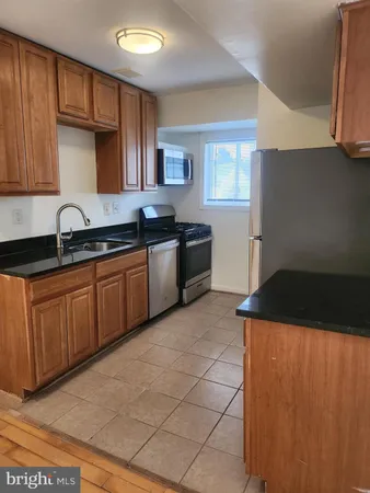 a kitchen with stainless steel appliances granite countertop a sink a stove and a refrigerator