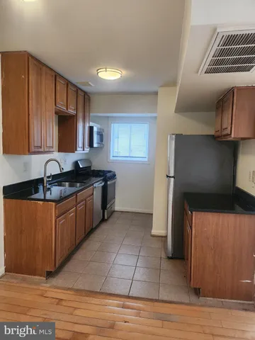 a kitchen with stainless steel appliances granite countertop a sink stove and cabinets